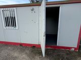 an open white and red container sitting on top of a dirt field