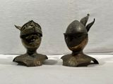 paire de figurines anciennes en laiton représentant un homme et une femme portant des casques