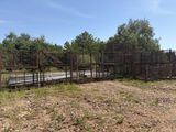 a fence that is next to a road and some trees