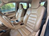 l'intérieur d'une voiture avec des sièges en cuir beige et un volant