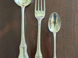 four silver spoons and two silver spoons on a table