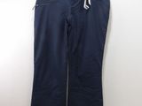 Le pantalon est bleu et noir, avec une bande blanche sur le côté.