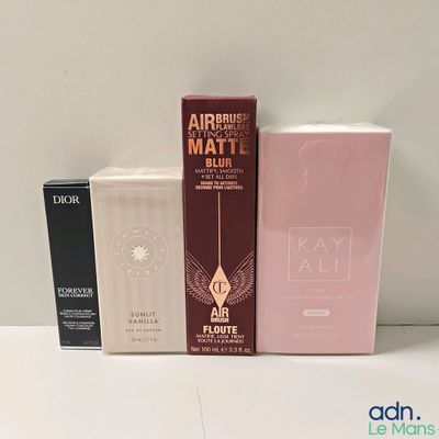 trois boîtes de matériel d'aérographie et une boîte de maquillage posées sur une table