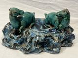 two frogs that are sitting on a rock together