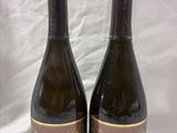 two bottles of wine sitting next to each other on a table