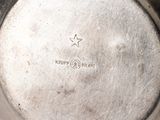 silver plate with a star engraved on the side of it