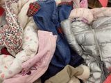 un tas de vêtements et un ours en peluche dans un panier
