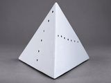 an image of a white paper pyramid on a gray surface
