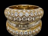 a close up of two gold rings with diamonds on a black background