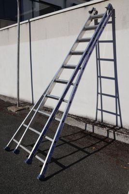 a ladder leaning against a wall on the side of the road