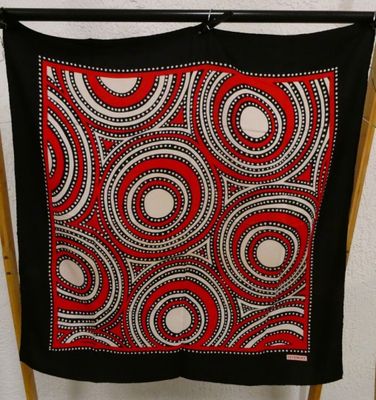 an image of a black and red scarf hanging on a clothes rack