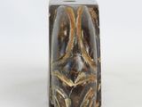 a brown and black marble block on a white surface