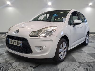 la petite voiture blanche est garée sur un sol en damier