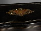 a small black box with a gold decoration on it