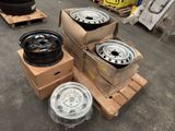 several tires and rims are stacked on pallets in a warehouse