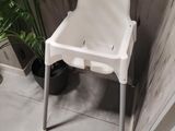 a white high chair in the corner of a bathroom