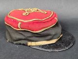 un chapeau rouge et noir posé sur un chapeau noir