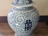 a blue and white vase with a lid sitting on a table