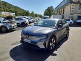 une voiture grise garée dans un parking à côté d'un bâtiment