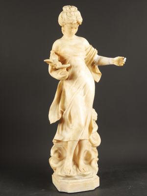 a statue of a woman holding a bird on a black background