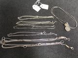 a lot of silver necklaces on a black surface