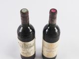 two bottles of wine sitting next to each other on a white surface