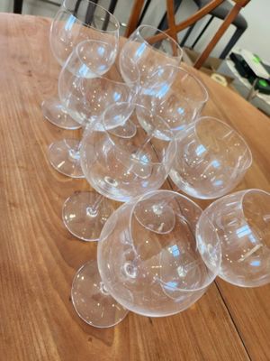 several empty wine glasses sitting on top of a wooden table
