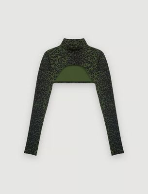 a woman wearing a green and black top with leopard print on it