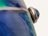 a close up view of a blue vase with a silver lid