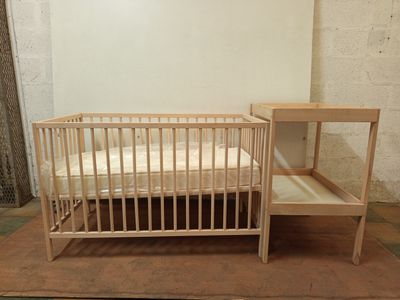 un lit de bébé et un lit dans une petite chambre