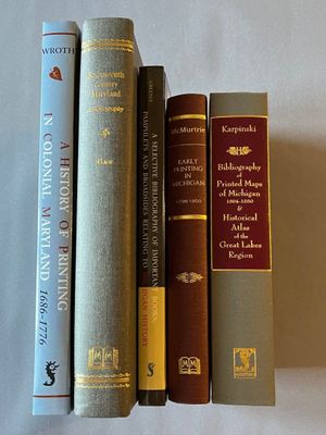 trois livres posés l'un à côté de l'autre sur une table