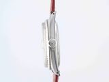 a close up of a watch on a red cord with a white background