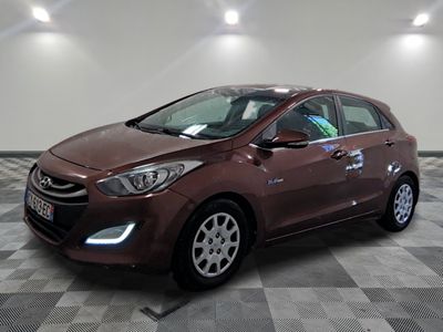 La voiture marron est garée sur un sol carrelé à damier.