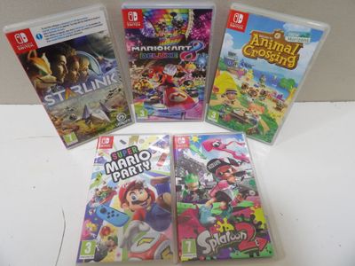 Quatre jeux Nintendo Wii sont posés sur une table