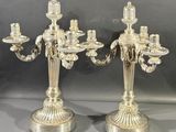 paire de chandeliers plaqués argent avec des bougies sur leurs socles