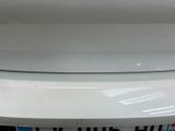 the rear end of a white car with a sticker on it ' s bumper