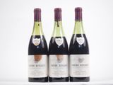 trois bouteilles de vin sont alignées sur une surface blanche