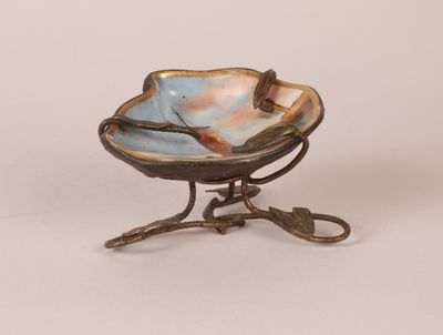 a small bowl on a stand with a bird on it