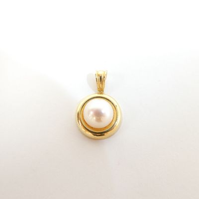 an image of a gold pendant with a pearl in the center
