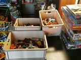 Plusieurs bacs remplis de jouets sont empilés les uns sur les autres dans une pièce.