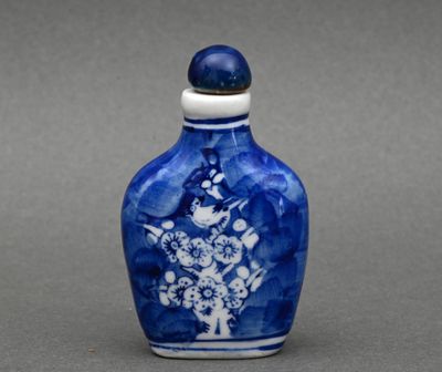 un petit vase bleu et blanc orné de fleurs