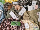 a lot of clothes that are sitting on a bed
