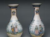 une paire de vases décorés de personnages, posés sur une table