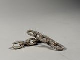 pair of silver snake bracelets with diamonds on a white background