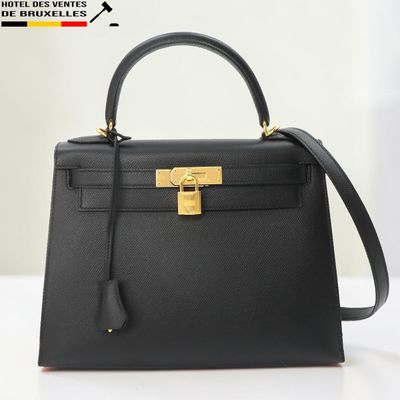 un sac à main en cuir noir muni d'un fermoir doré sur la poignée