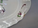 a plate with flowers painted on it sitting on a table