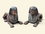 deux statues de pharaons allongés sur une surface beige