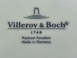 the porcelain plate has a black and white logo on it