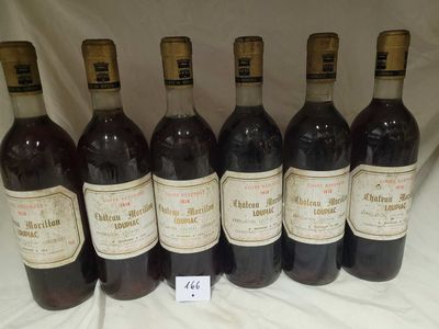 six bottles of red wine are lined up on a table