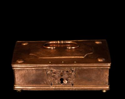 une boîte métallique munie d'une poignée sur fond noir